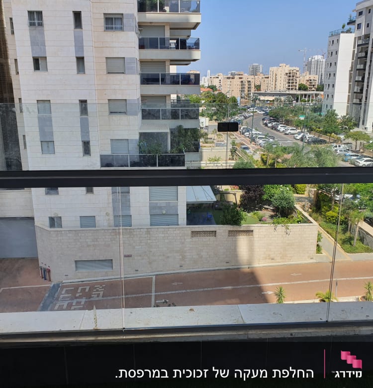 מעקה זכוכית במרפסת עם נוף עירוני